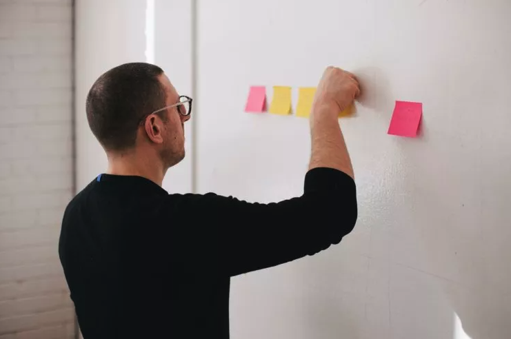 A lawyer putting Post-It notes on the wall with potential law firm names