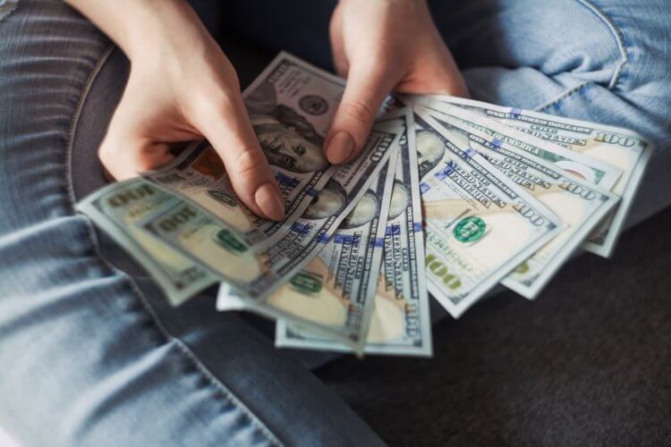 person sitting on the ground holding money