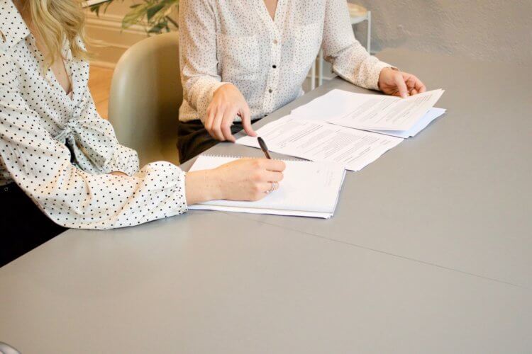 Two people sitting at a table reviewing contracts