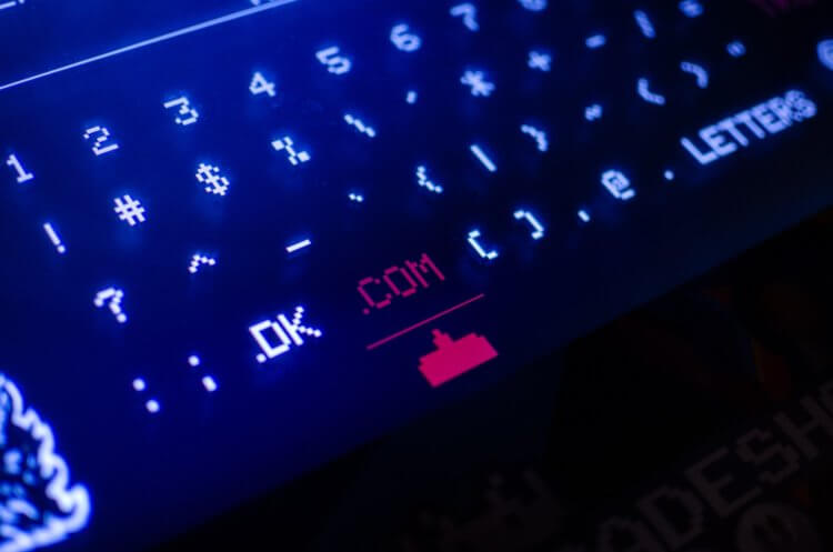 A photo of a tablet screen keyboard with a focus on the '.com' button