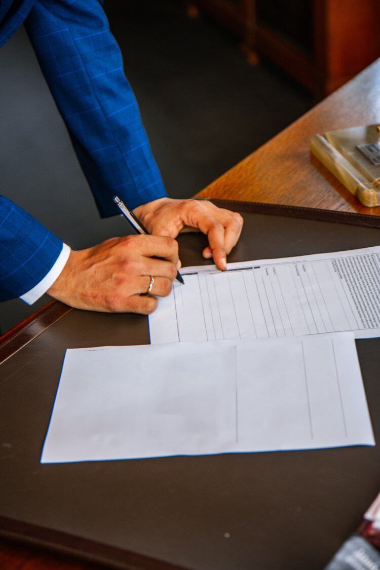 Photo of someone's hands writing on a legal document