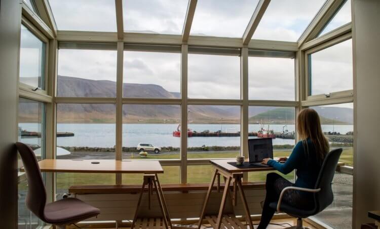 Photo of someone working remotely on their laptop in a cafe by the ocean