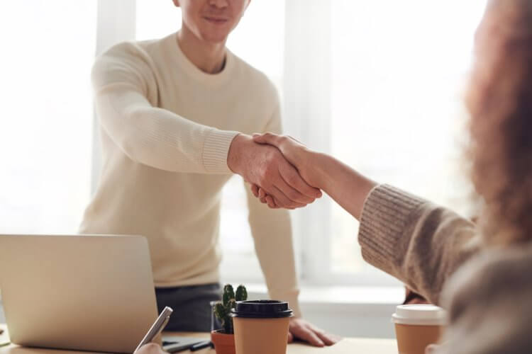 Lawyer and law firm client shaking hands over table