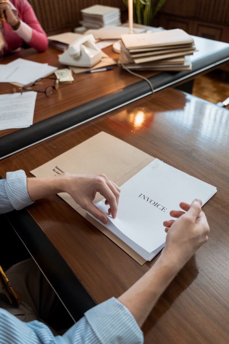 Person reviewing legal fee financing invoice at a desk