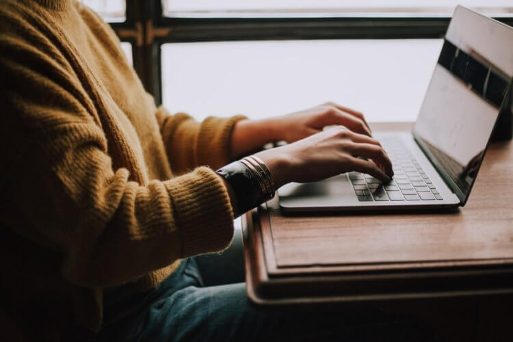 A close-up photo of someone typing on a laptop.