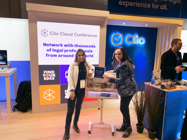 A photo of two Clio employees working at Clio's booth at the 2022 ABATECH SHOW