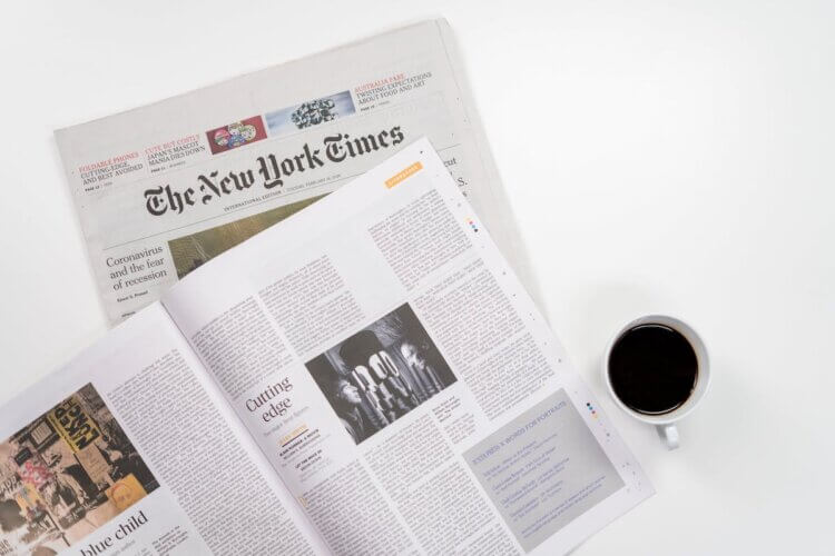Image of newspapers next to a cup of coffee