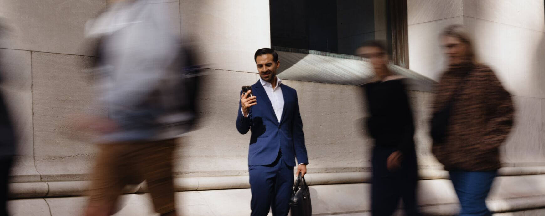 Lawyer looking at phone as people walk by - Communication and marketing